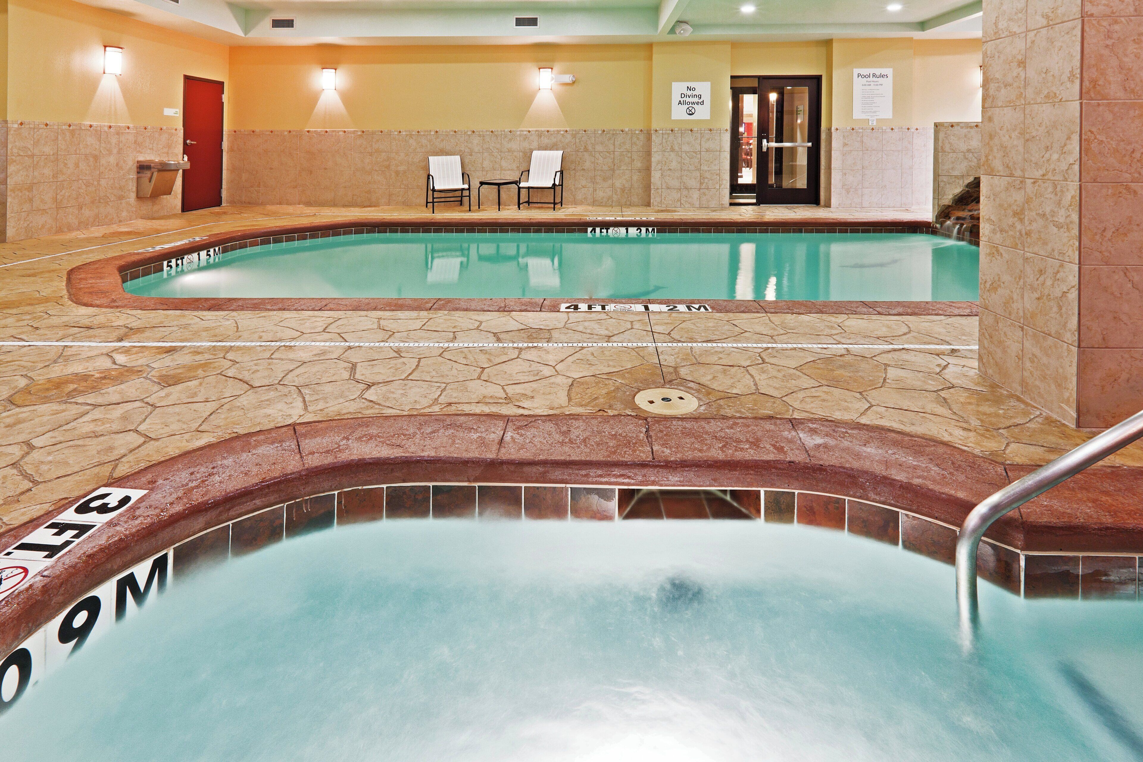 Área de piscina de hotel com duas piscinas, espreguiçadeiras e aviso proibindo saltos.