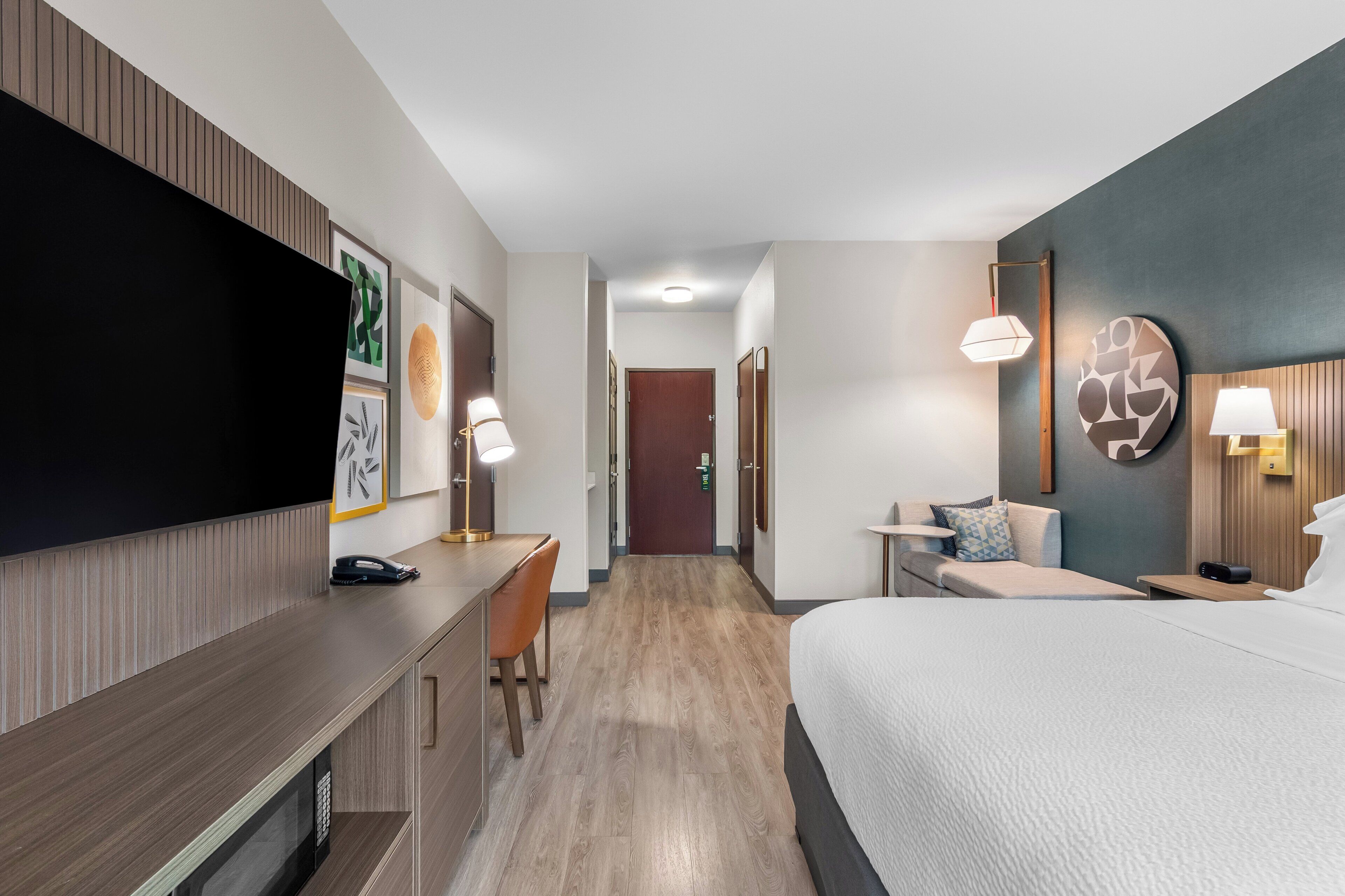 Une chambre d’hôtel équipée d’un lit, d’un bureau, d’une chaise et d’un téléviseur.