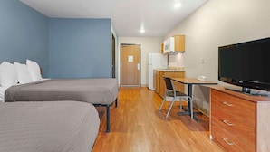 A compact hotel room with two beds, a kitchenette, a TV, and a desk. - Extended Stay America Select Suites - Cincinnati - Florence - Airport (Florence)