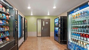 A vending area with snack and drink machines, a door, and a tiled floor. - Extended Stay America Select Suites - Cincinnati - Florence - Airport (Florence)