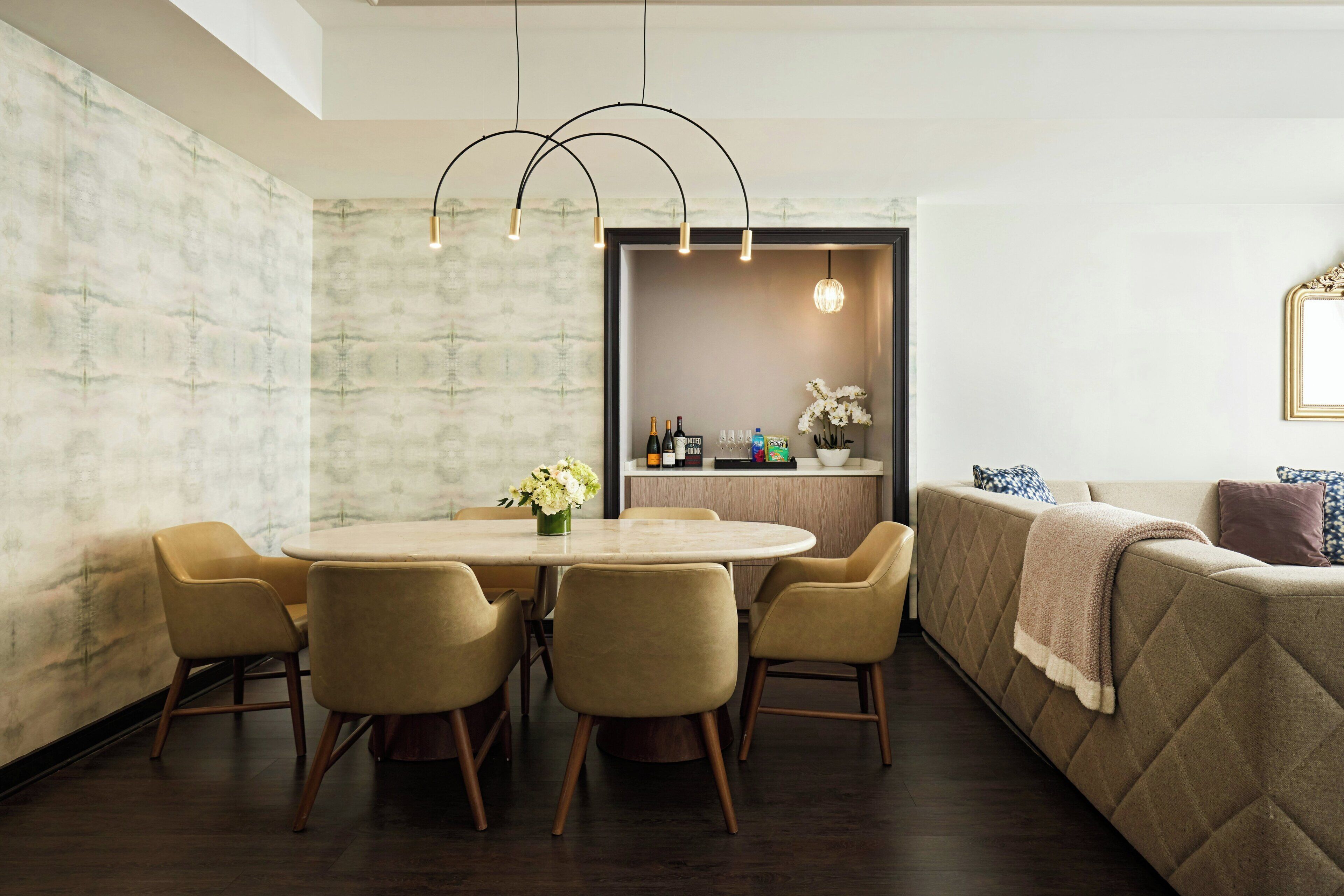 Un comedor moderno con una mesa redonda, sillas y una cocina al fondo.