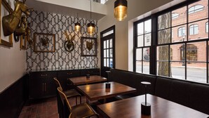 L’intérieur d’un restaurant présente des murs aux motifs géométriques, des tables et des bancs en bois.