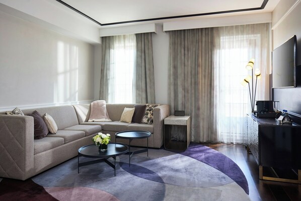 A modern living room with a sofa, coffee table, and a flat-screen TV.