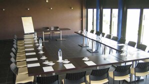 A conference room with a long table, chairs, water bottles, and name cards. - Résidence Hôtelière des Ondes (Saint-Lys)
