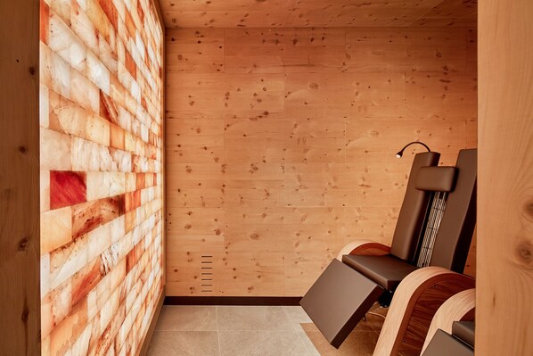 A wooden interior with a sloped ceiling, a bench, and a wall with a unique pattern.