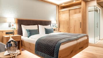 A modern bedroom with a wooden bed frame, a large window, and a wooden wardrobe.