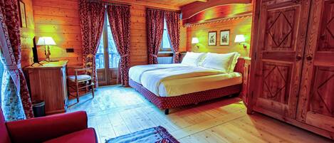 Un dormitorio rústico de cabaña de madera con una cama, una silla, una mesita y un armario.