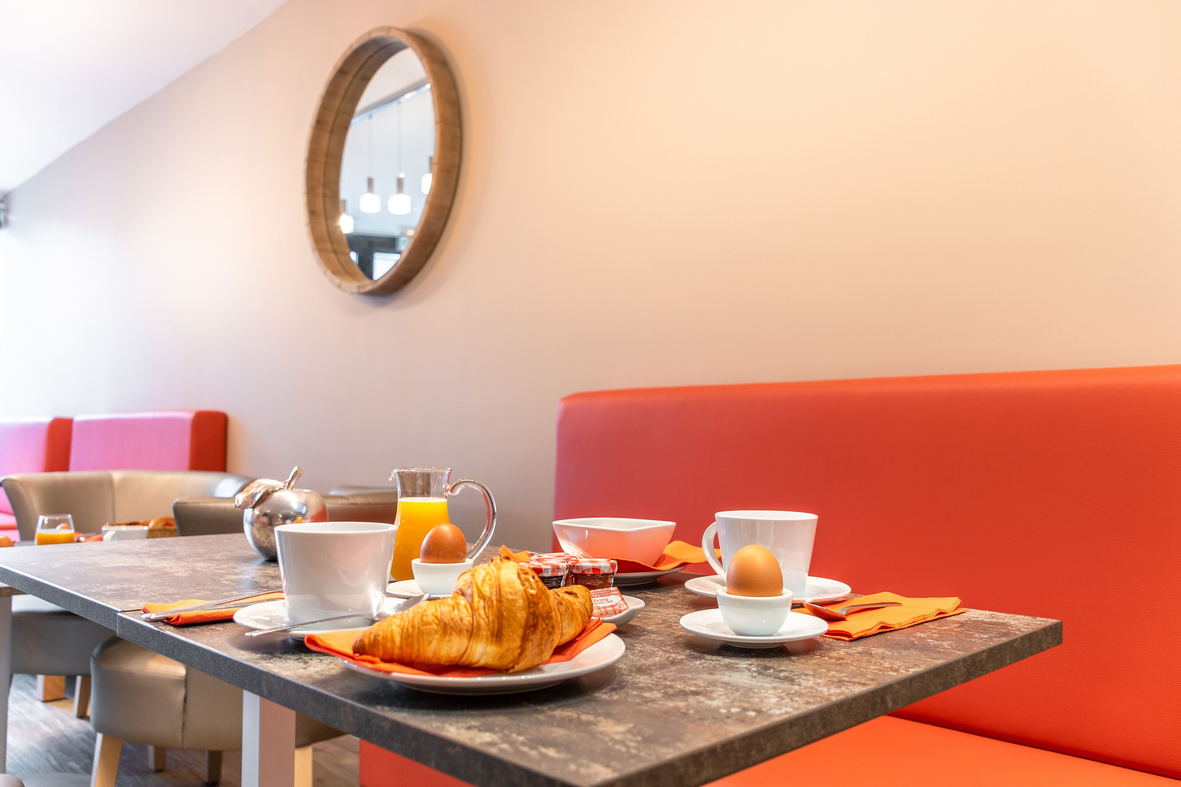 Taula de l'esmorzar amb croissants, tasses de cafè i suc d'aranja.