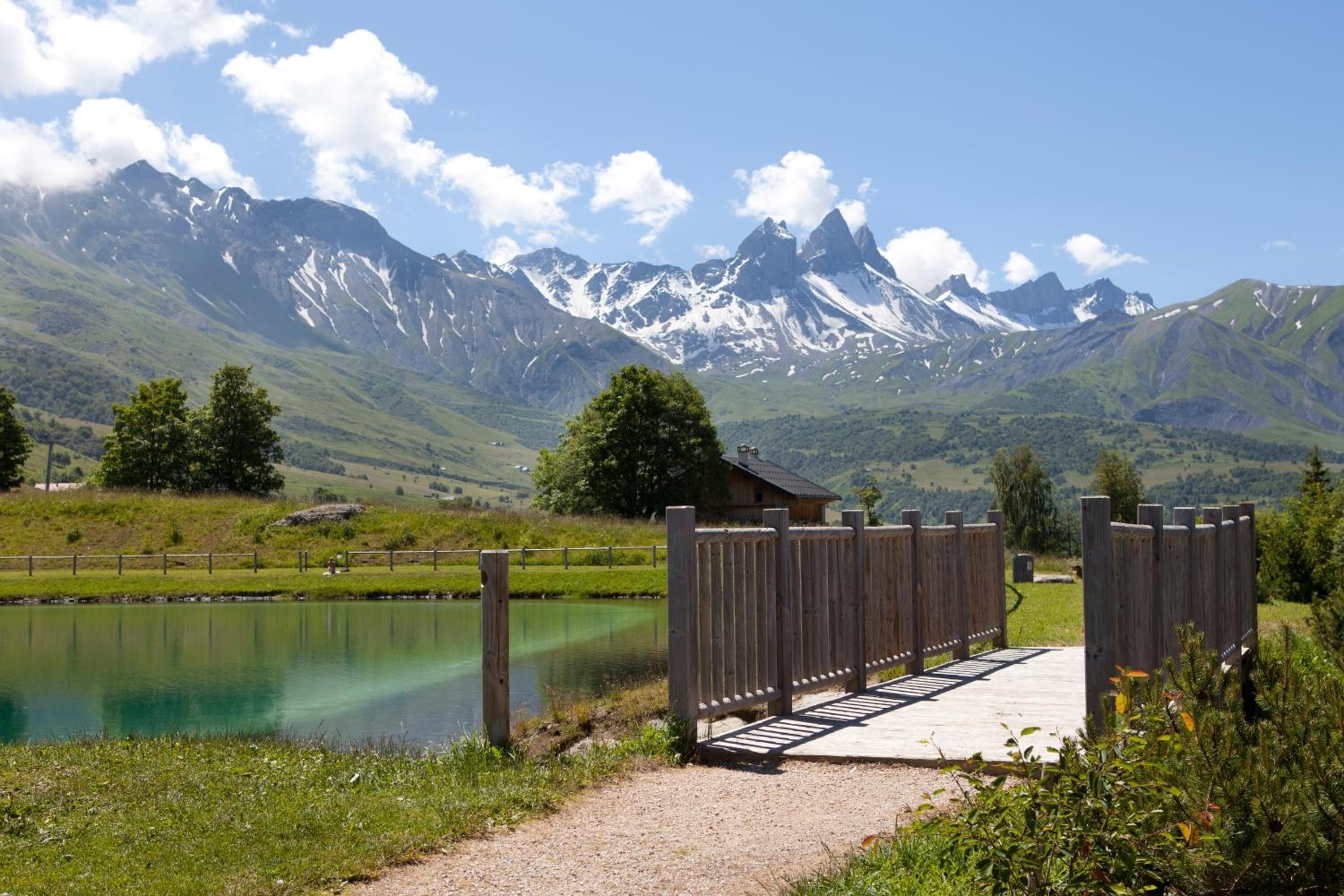 Una terraza de madera que conduce a una cabaña rústica con el paisaje de montañas al fondo.