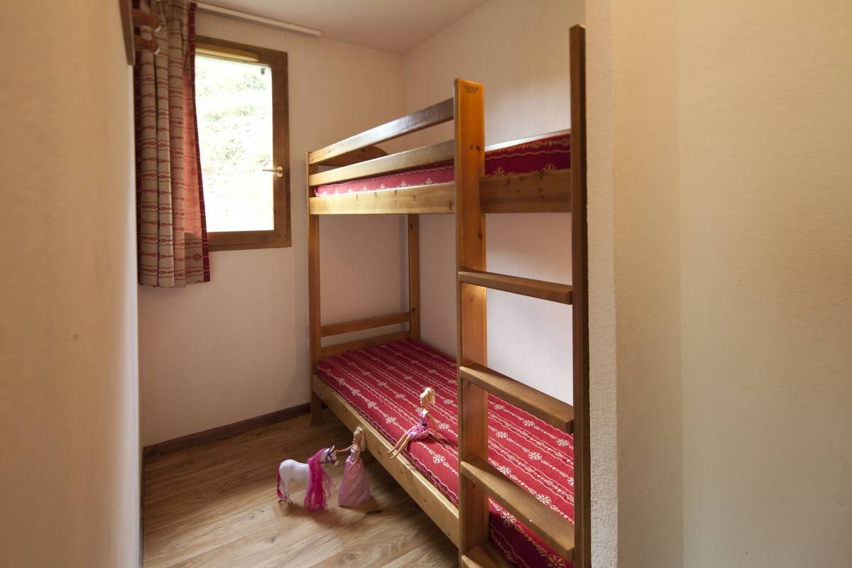 Habitación con literas, ventana y cortinas.