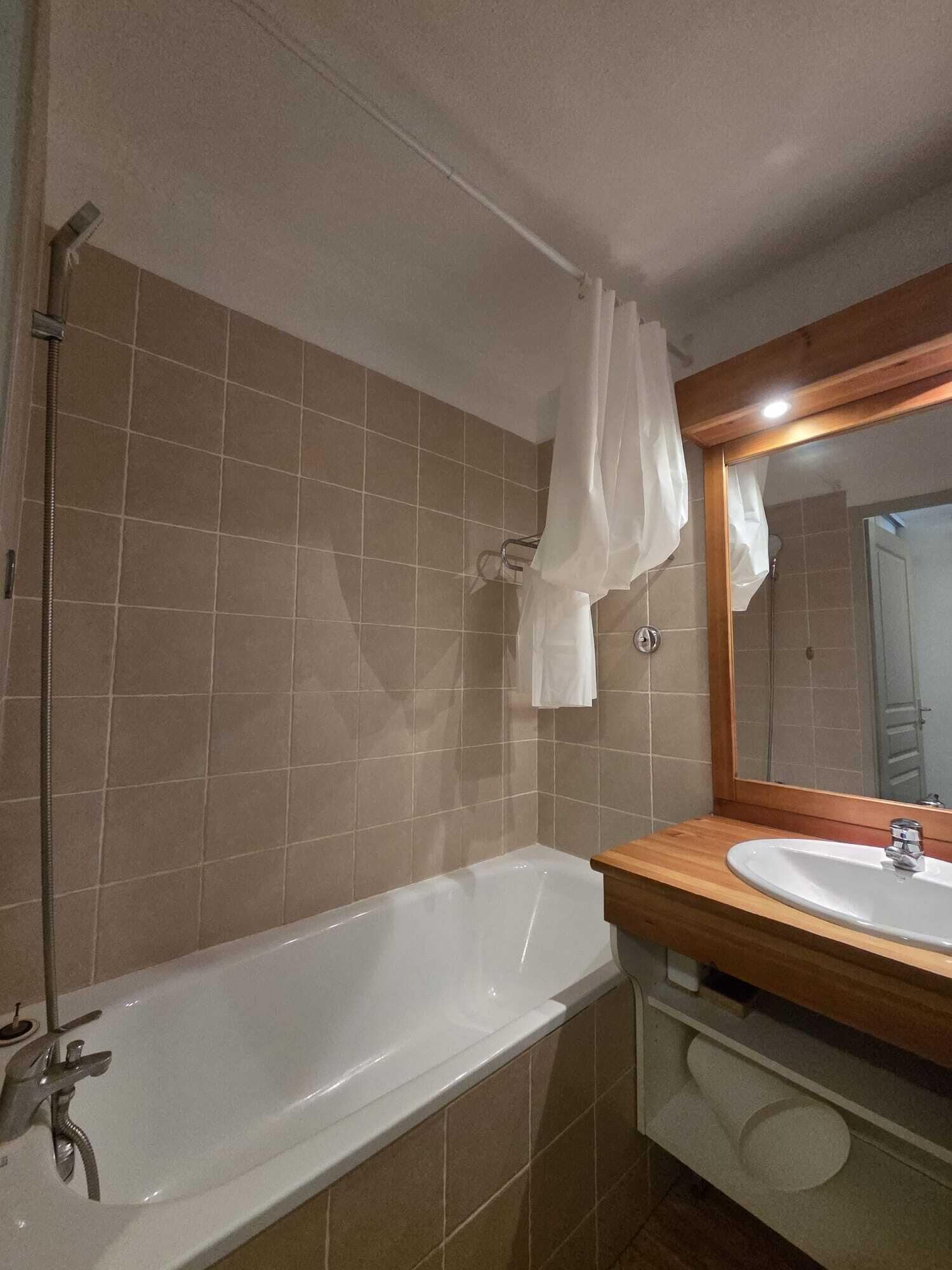 Ein Badezimmer mit einer Badewanne, einem Waschbecken, einem Spiegel und einer Duschvorhang.