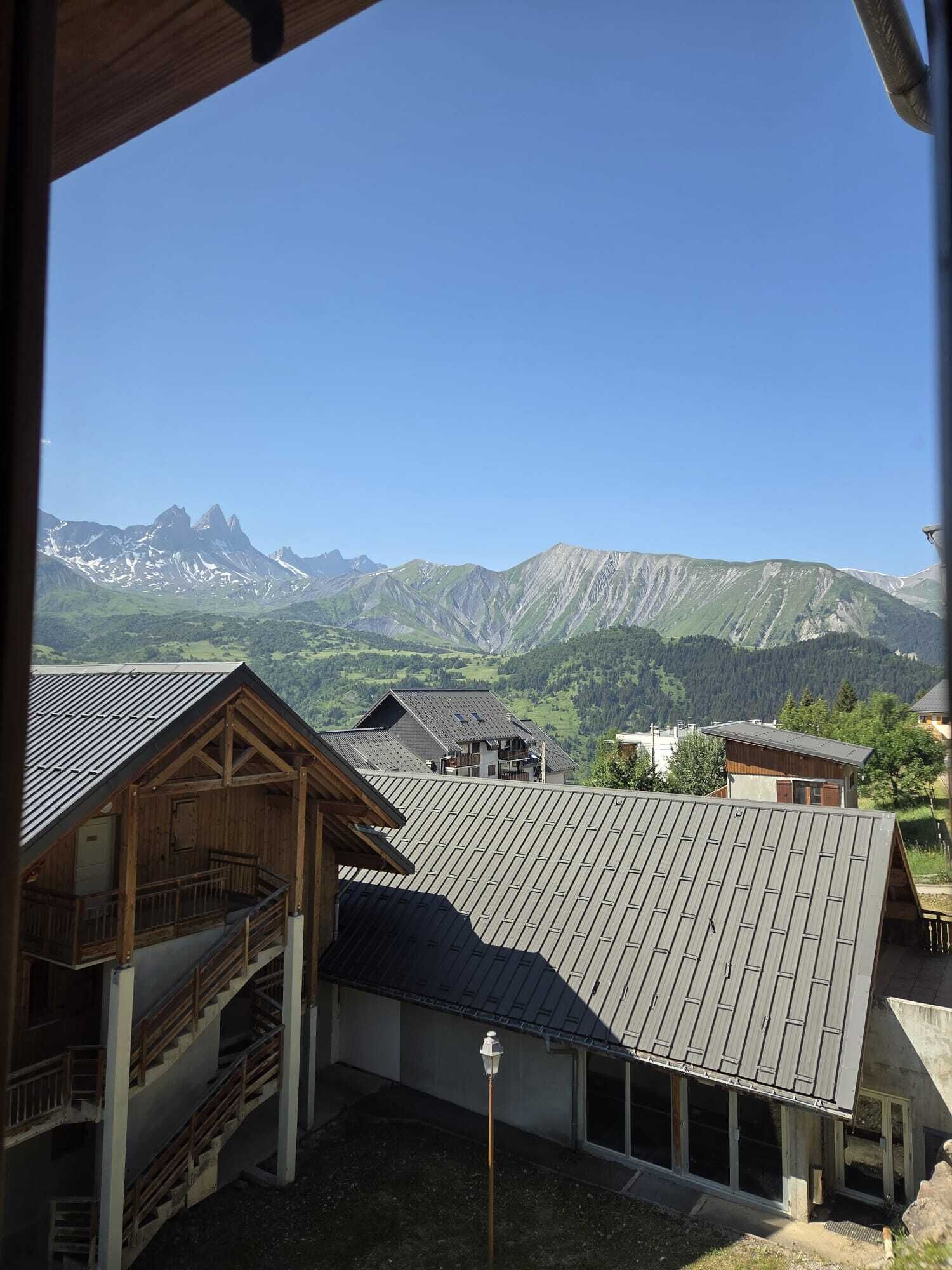 Vista de una cadena montañosa con una construcción de madera en primer plano.