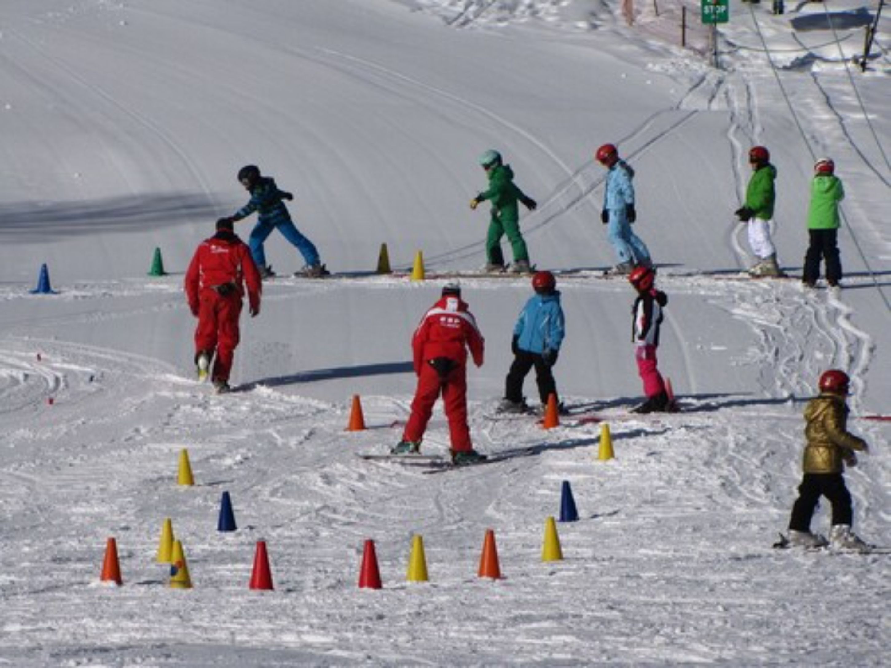 Pista nevada para esquiar con esquiadores y snowboarders en movimiento.