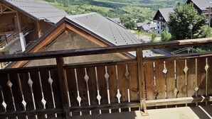A balcony with a view of a mountain range and a village below. - VVF Résidence Albiez-Montrond Maurienne (Albiez-Montrond)