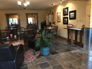 A spacious living room with a large dining area, a blue potted plant, and a fireplace.