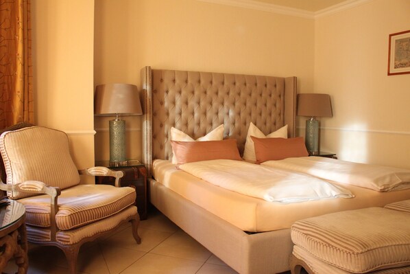 A hotel room with a large bed, two bedside tables, a chair, and a lamp. - Hotel Villa Sommer (Bad Doberan)