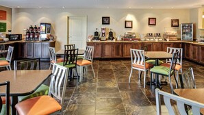 A hotel restaurant with a counter, seating area, and various food and beverage stations. - Comfort Suites near Hot Springs Park (Hot Springs)