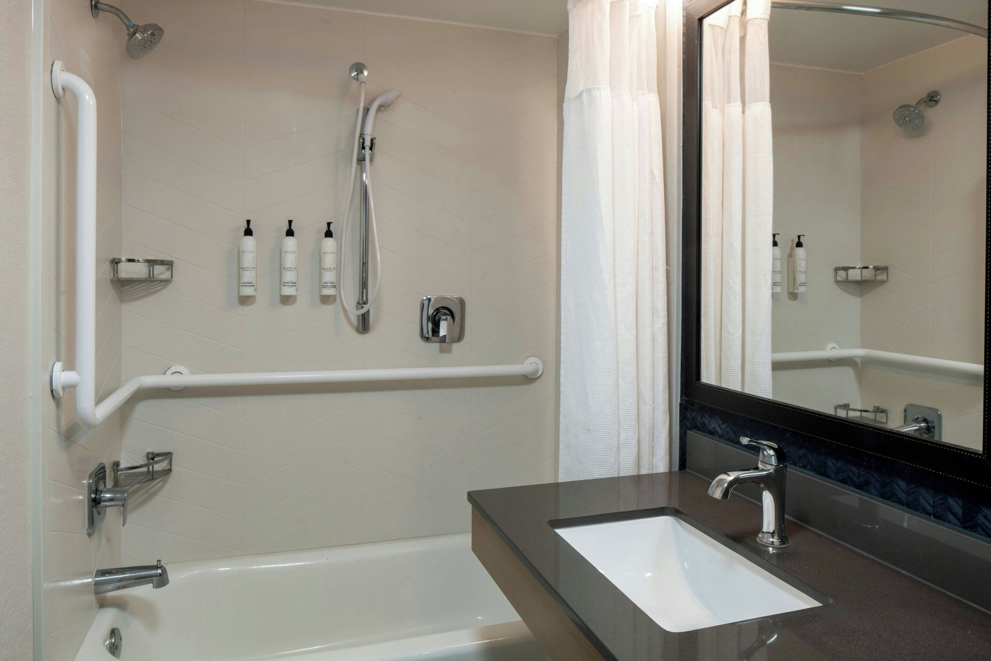 Ein Badezimmer mit Badewanne, Waschbecken, Dusche und Spiegel.