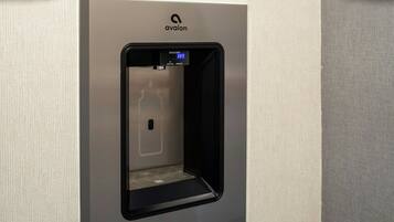 Een wandwaterdispenser met een digitaal scherm, merk 'avalon'.