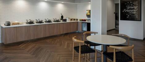 A modern kitchen with a white tiled backsplash, wooden cabinets, and a built-in coffee station.