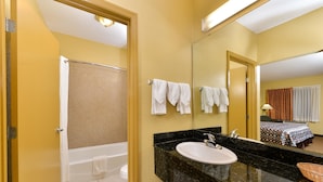A bathroom with a bathtub, a sink, and a mirror.