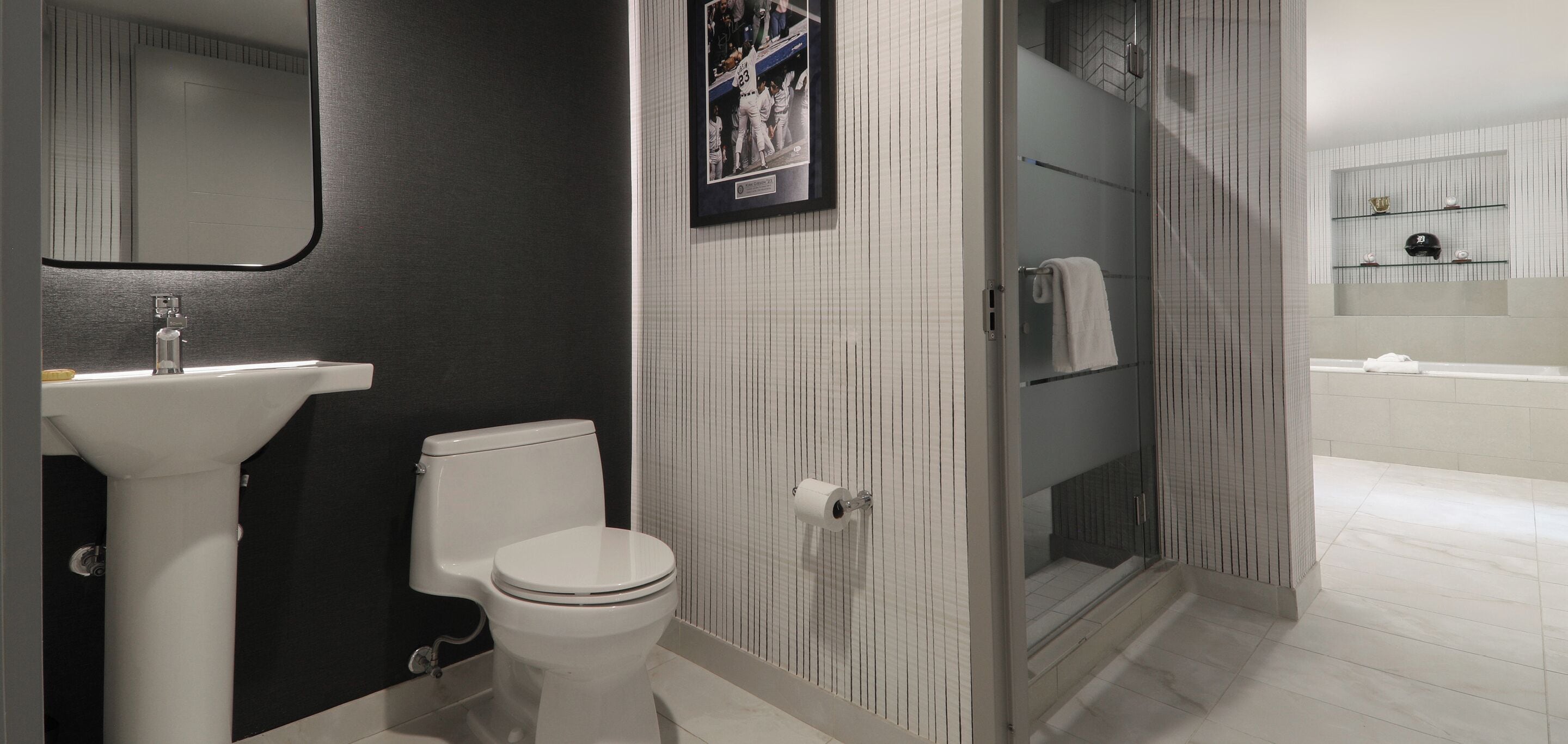 A modern bathroom with a toilet, sink, and shower area.