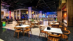 A spacious indoor dining area with multiple tables and chairs, a bar area, and a visible exit. - Hollywood Casino at Greektown (Detroit)