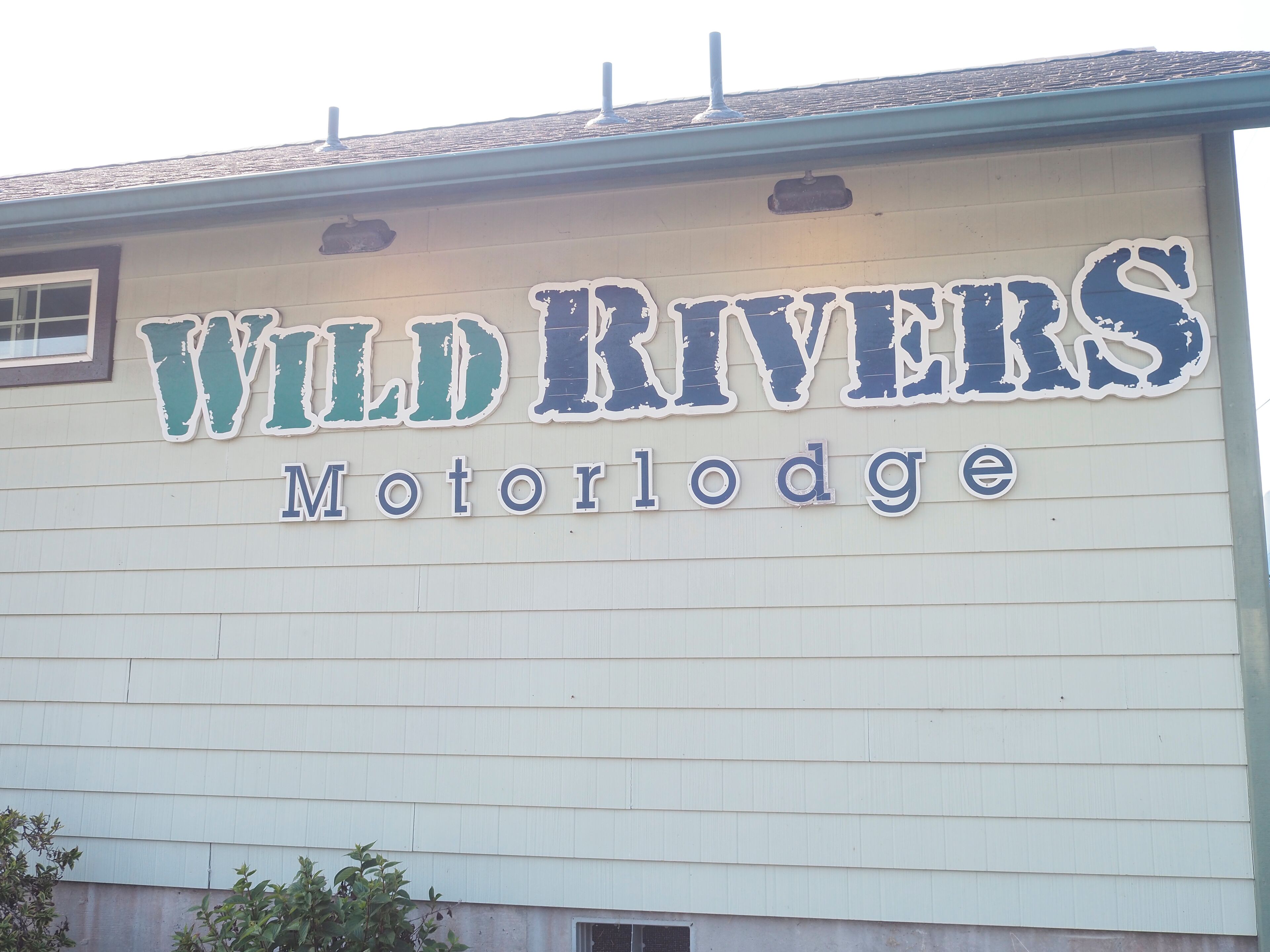 A building with a sign that reads "Wild Rivers Motor Lodge".