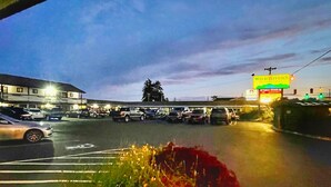 A parking lot with multiple cars and a building with a sign for Wild Rivers Motel.