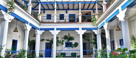 Un patio con arquitectura en blanco y azul, con arcos y balcones.