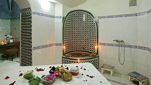 A bathroom with a checkered mosaic wall, a bathtub, and a shower area. - Riad Al Madina (Essaouira)