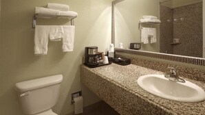Een badkamer met toilet, wastafel en handdoekhouder.