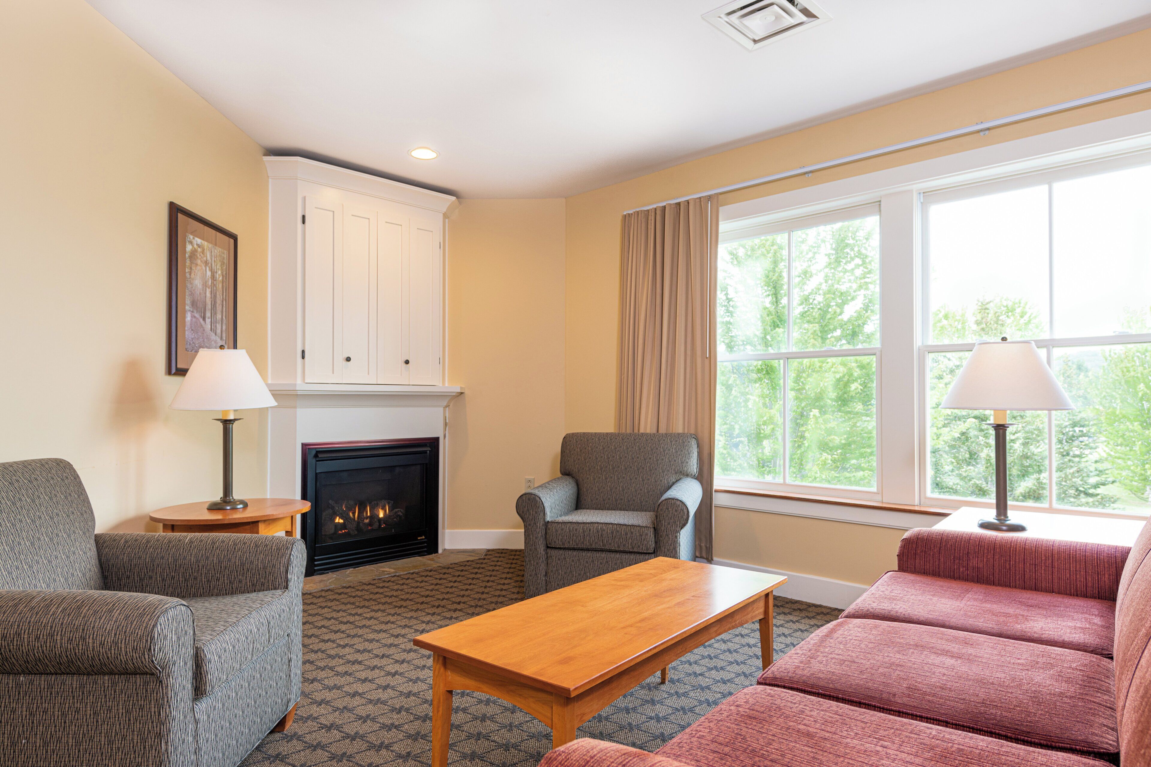 A living room with a fireplace, a sofa, a chair, and a table.