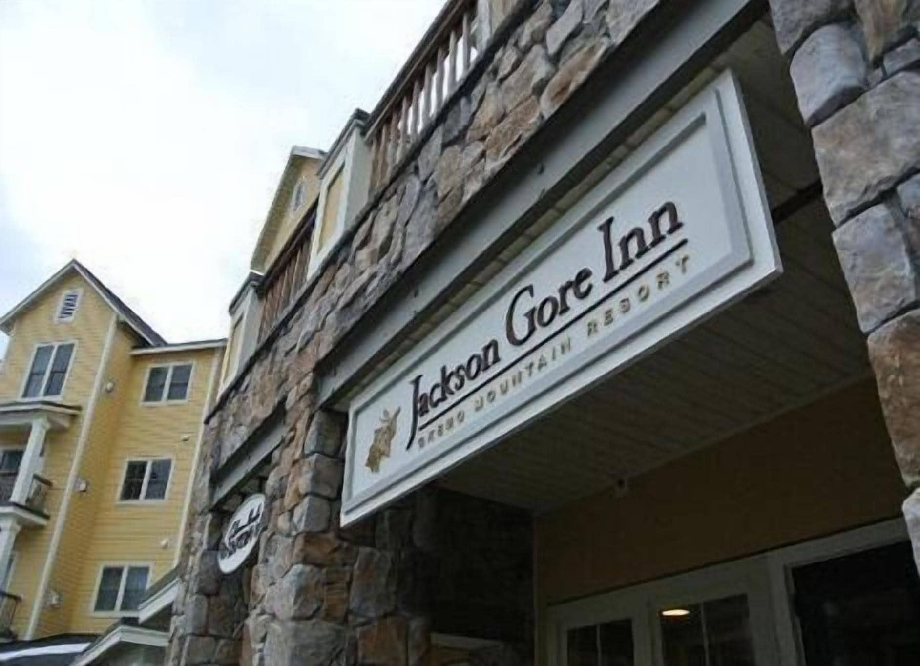 L’extérieur de l’hôtel Jackson Gore Inn, un complexe hôtelier de montagne doté d’une façade en pierre et d’une enseigne.