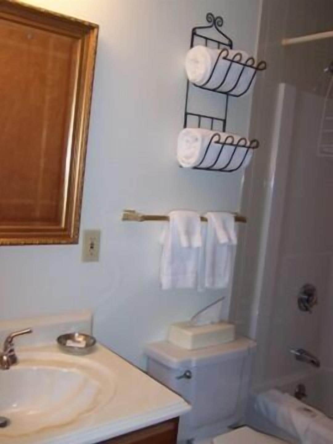 Un baño con lavamanos, inodoro y toallero.