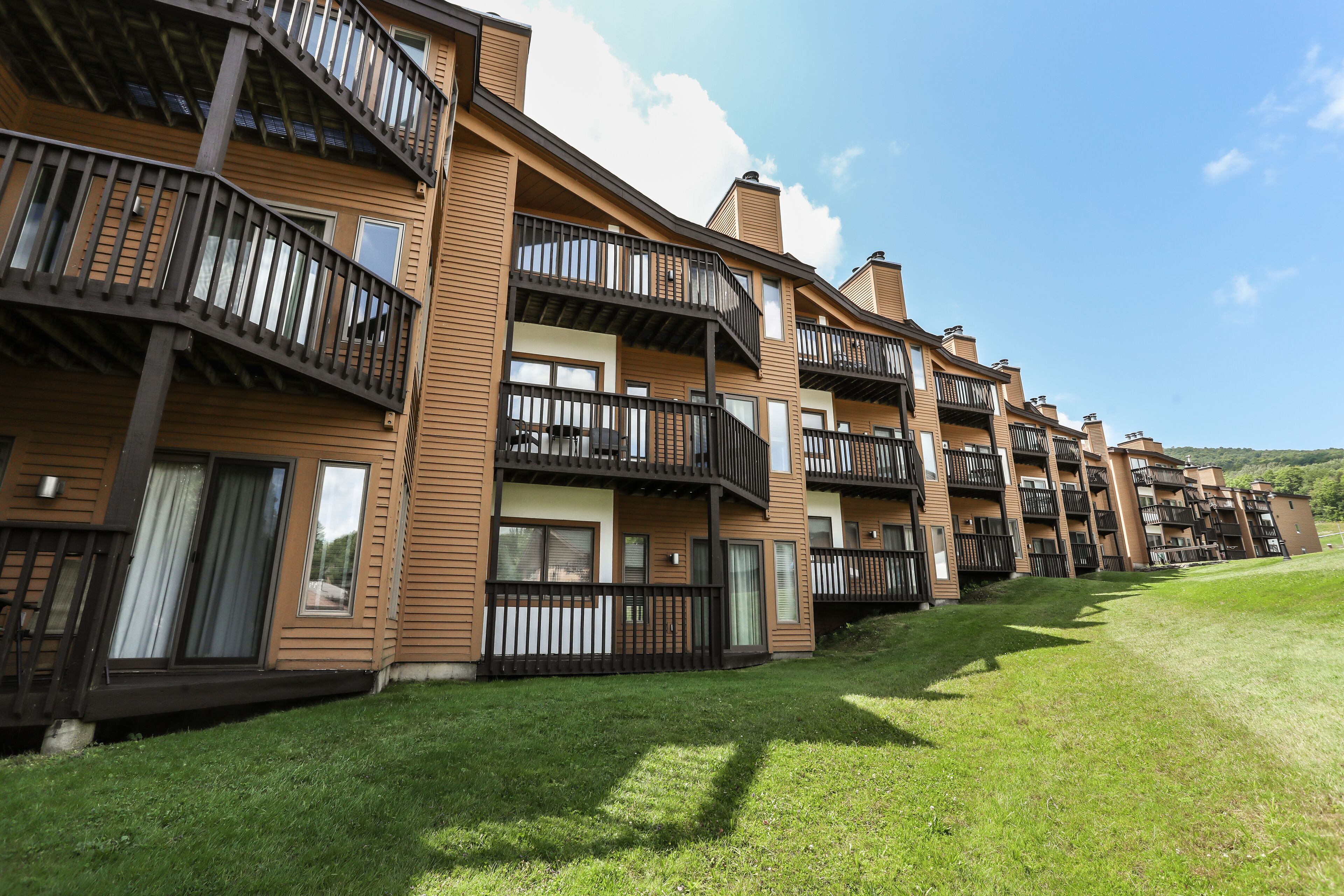Une rangée d’immeubles modernes à plusieurs étages, dotés de balcons et de grandes fenêtres.