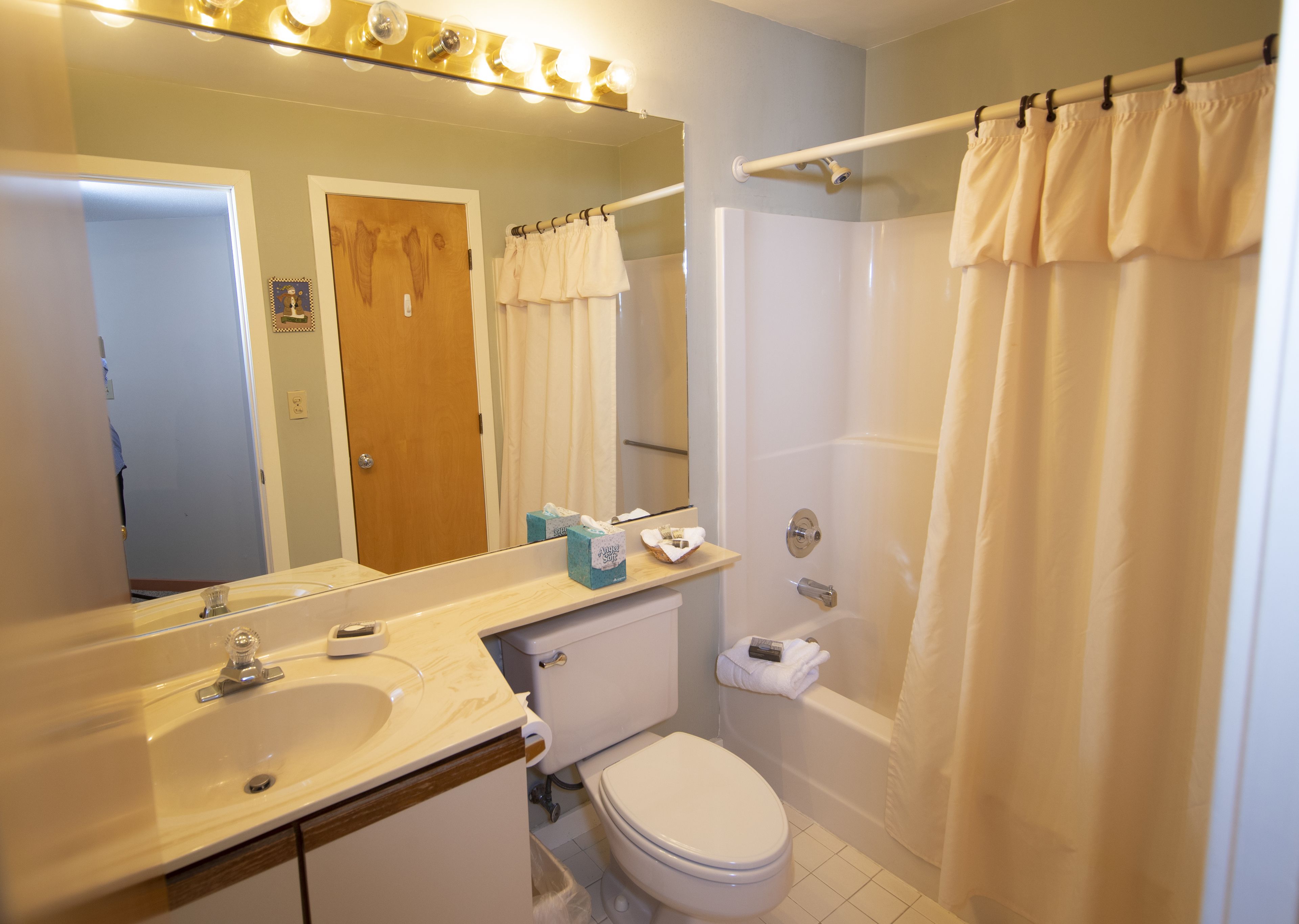 A bathroom with a sink, toilet, and shower.