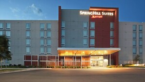 Un hotel con fachada moderna, un letrero destacado de Springhill Suites Marriott y un área de entrada cubierta.