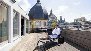 Relax on the rooftop terrace with a clear view of the historic cityscape, featuring a prominent dome and spires.
