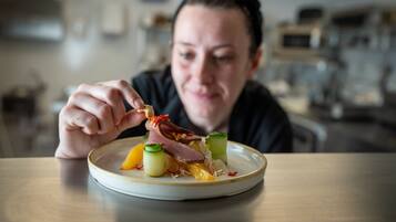 A person seated at a table with a plate of food.