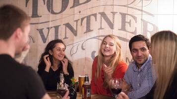 A group of people sitting at a table in a restaurant with a large sign in the background.