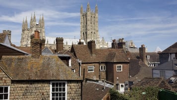A historic building with a prominent tower and adjacent residential buildings with brick facades and pitched roofs.