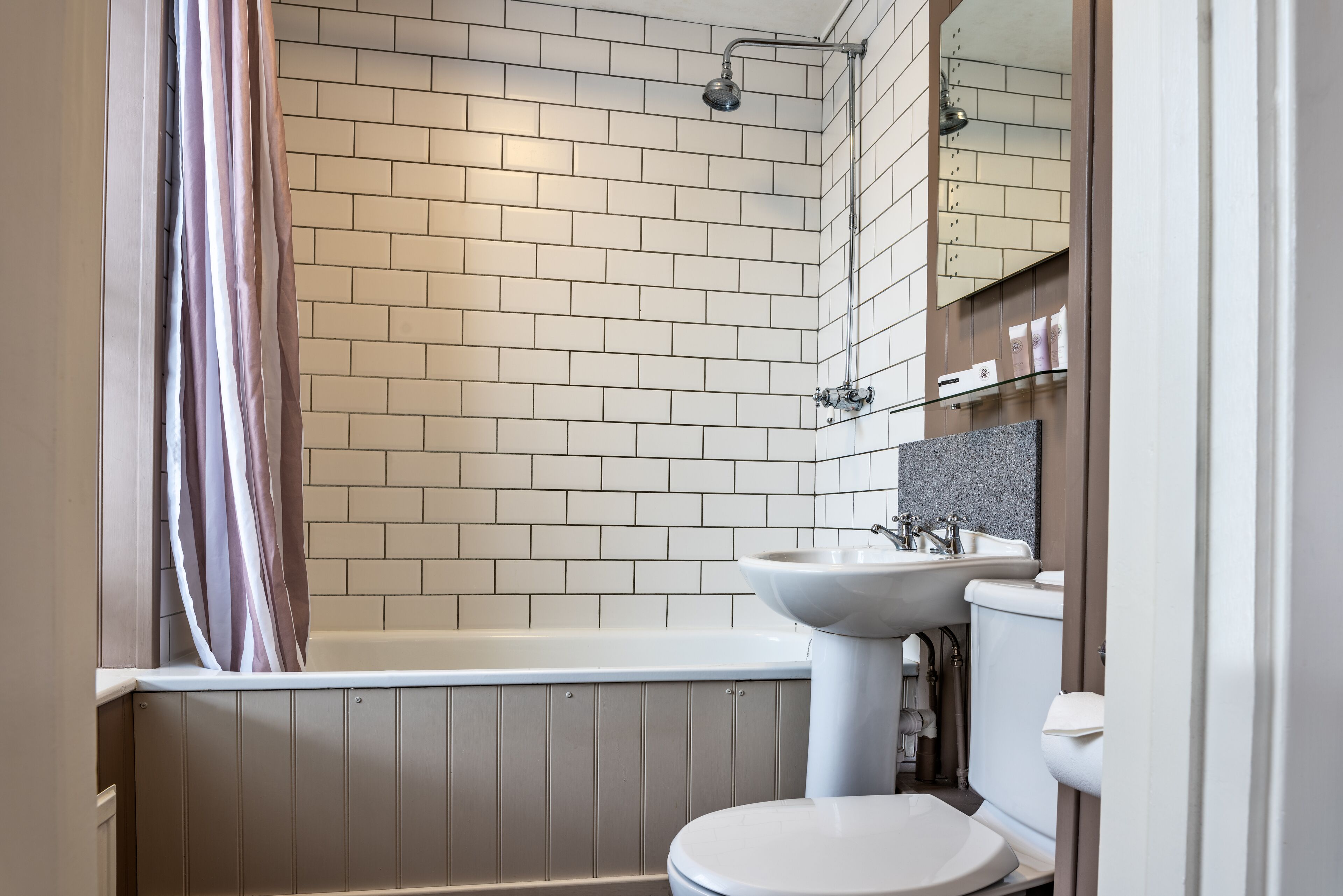 A modern bathroom with a bathtub, a sink, and a toilet.