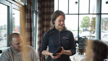 L’intérieur d’un restaurant est agrémenté de grandes fenêtres, d’un bar et d’un espace détente avec des sièges confortables.