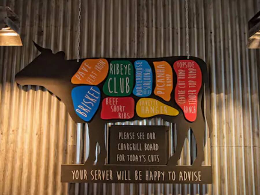 Ein Schild mit verschiedenen Speisen wie 'Beef Short Ribs' und 'Pecan Pie'.