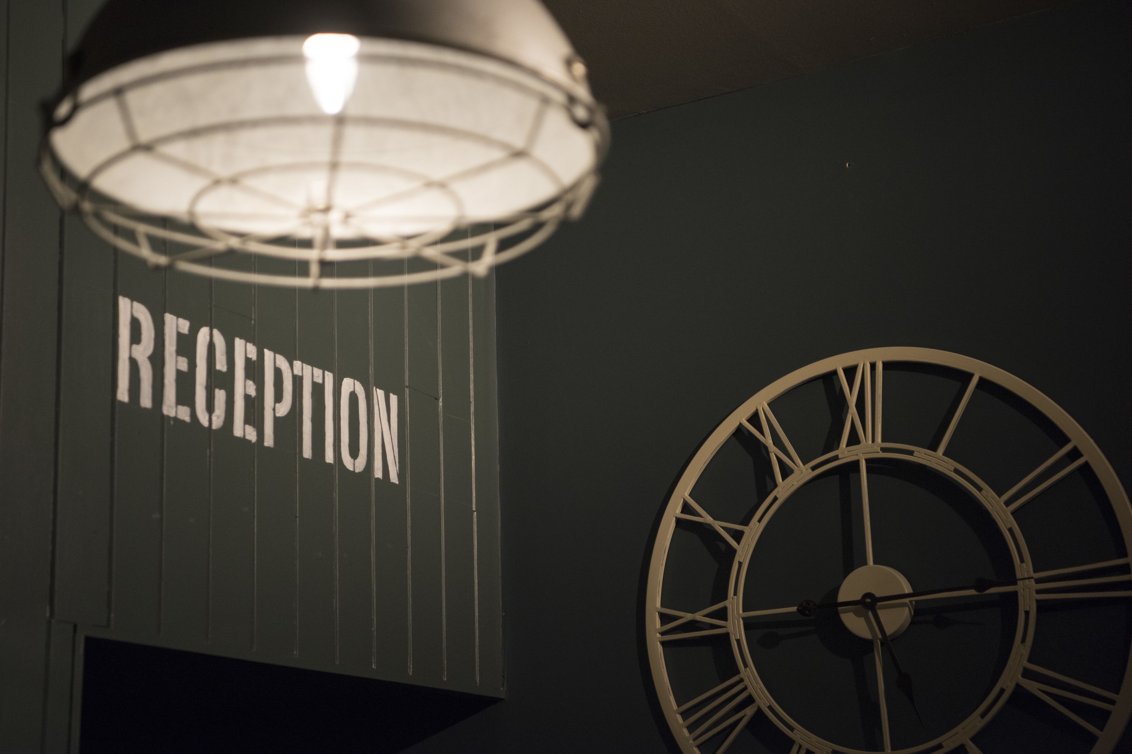Un espace d’accueil avec une horloge et un panneau indiquant « RÉCEPTION ».