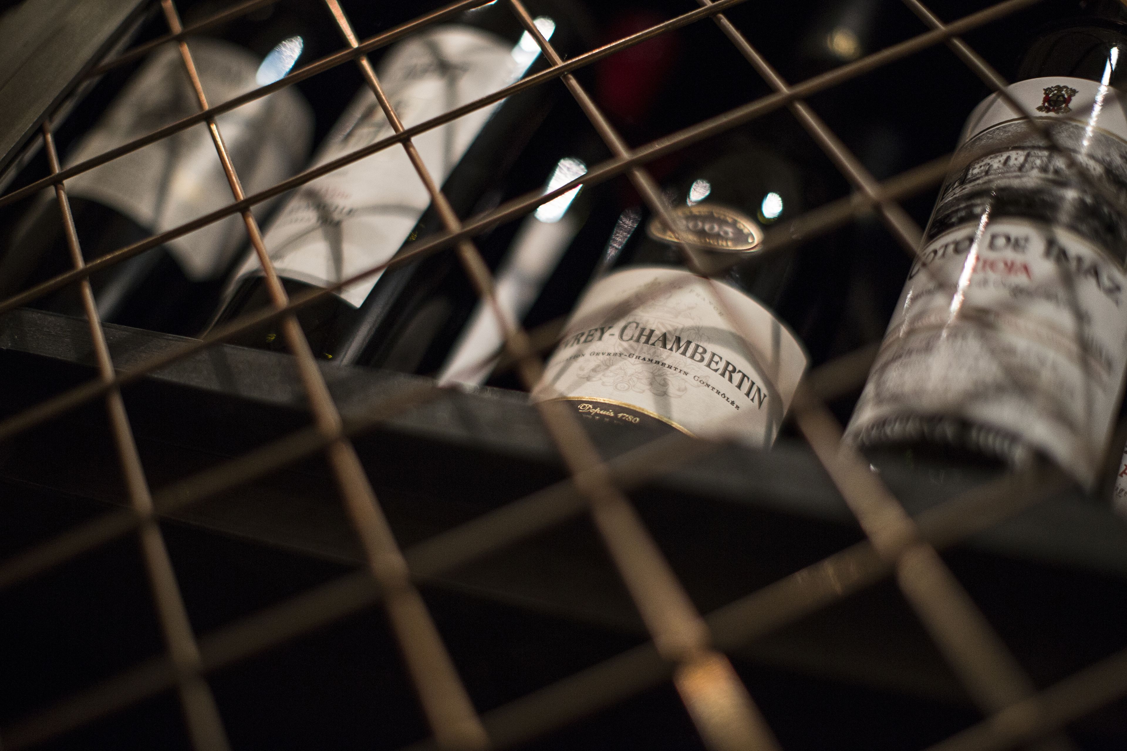 A wine rack with bottles, including a bottle labeled "Chambers."