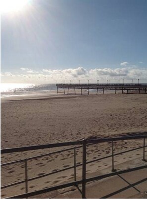 A beach with a pier extending into the water.