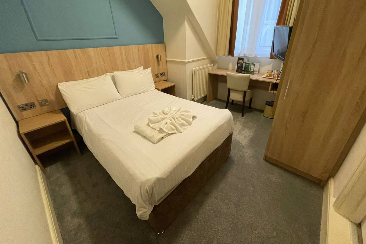 Ein Schlafzimmer mit einem Bett, einem Schreibtisch und einem Stuhl.