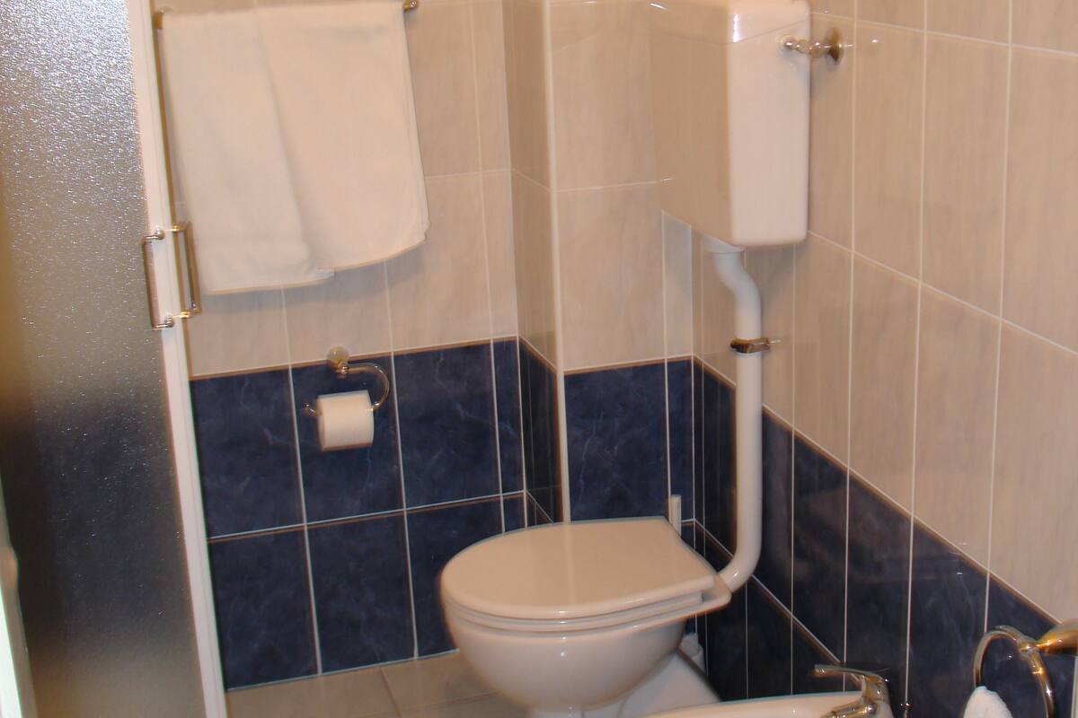 Et badeværelse med toilet, bidet og håndvask.